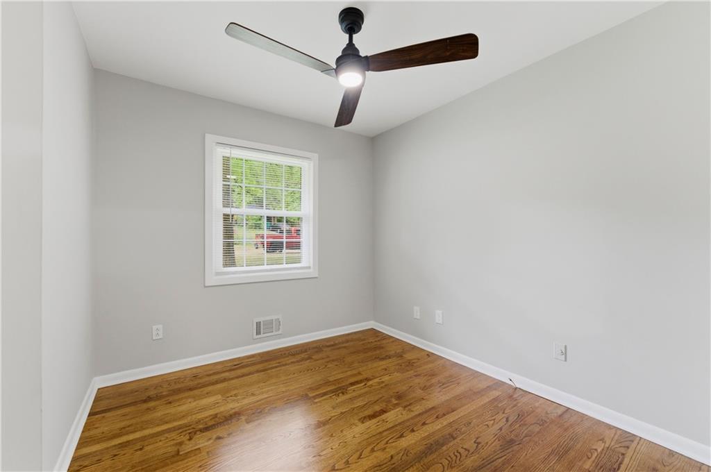 1063 Seville Drive Clarkston, GA 30021 - Photo 21 of 25 an empty room with a window and a ceiling fan