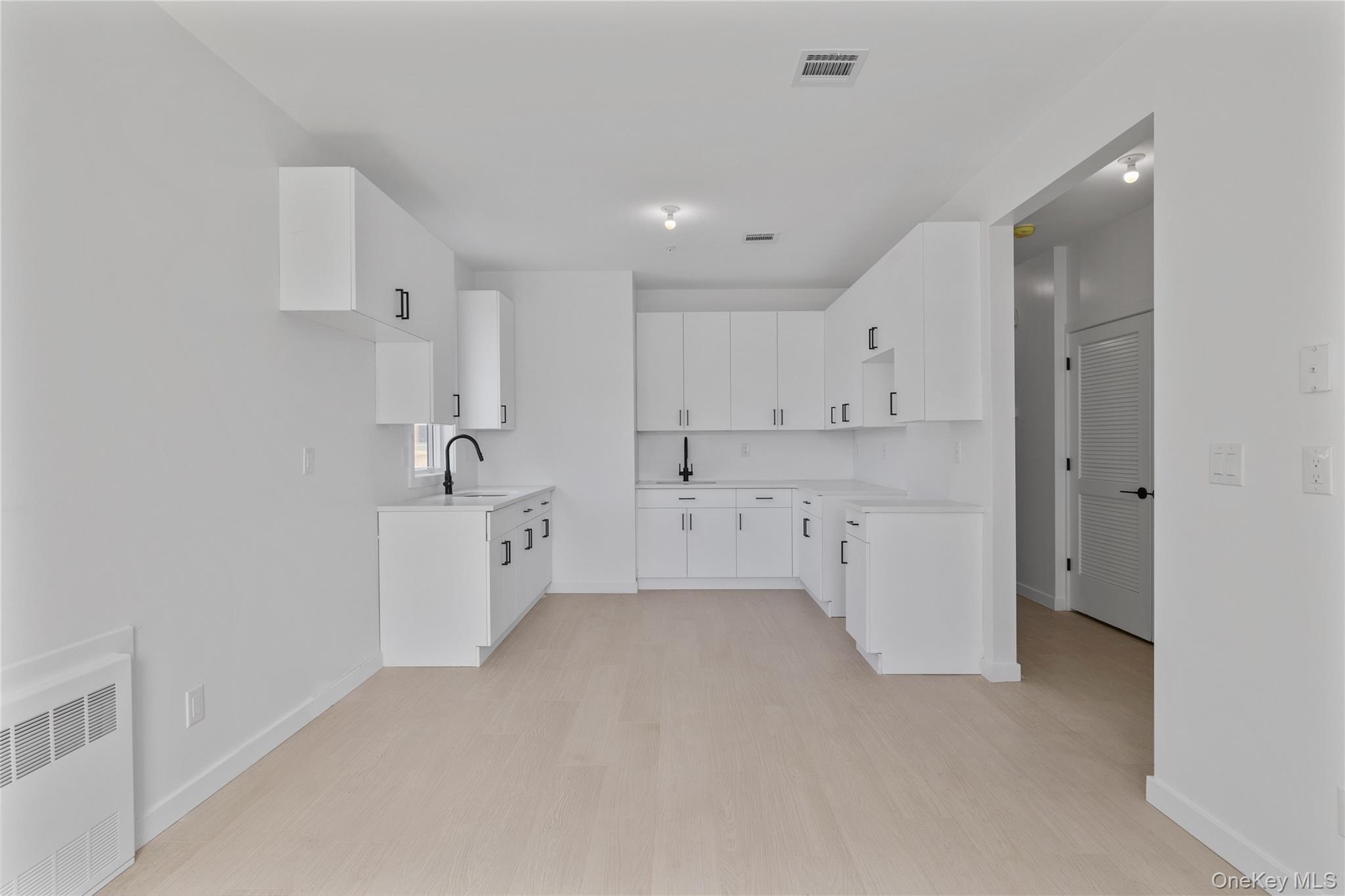 236 Old Nyack Turnpike, Unit 202 Spring Valley, NY 10977 - Photo 42 of 49 a large white kitchen with white cabinets