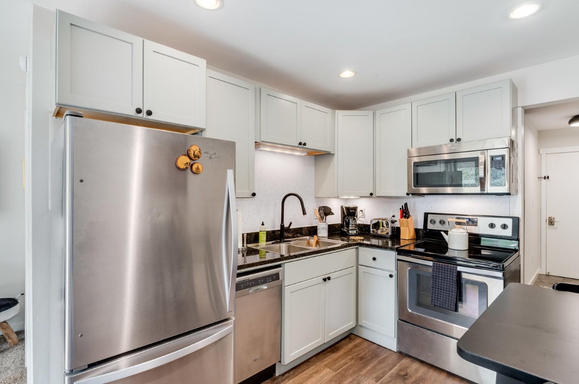 401 South Ridge Street, Unit 21 Breckenridge, CO 80424 - Photo 6 of 12 a kitchen with refrigerator a sink and white cabinets