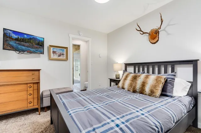 a bedroom with a bed and painting on the wall