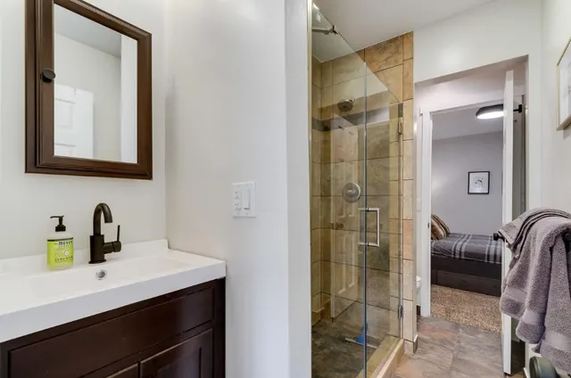 a bathroom with a shower sink and mirror