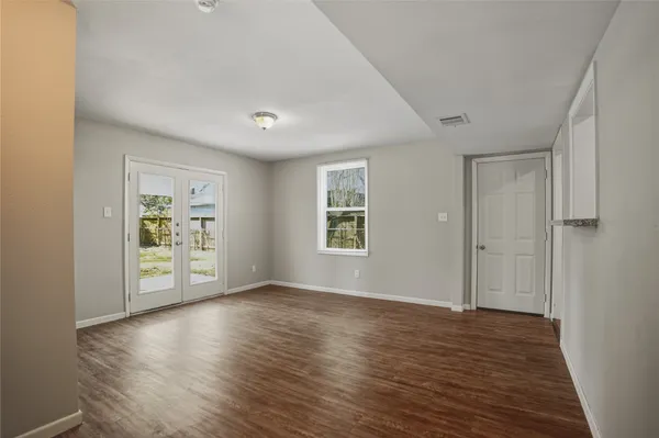 a view of an empty room with a window and a ceiling fan