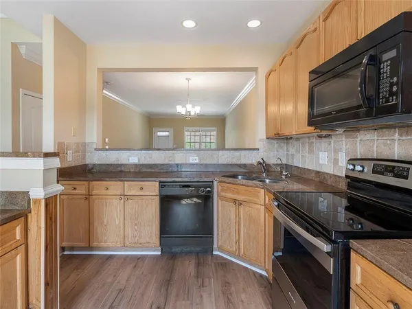 a kitchen with stainless steel appliances granite countertop a stove a sink and a microwave