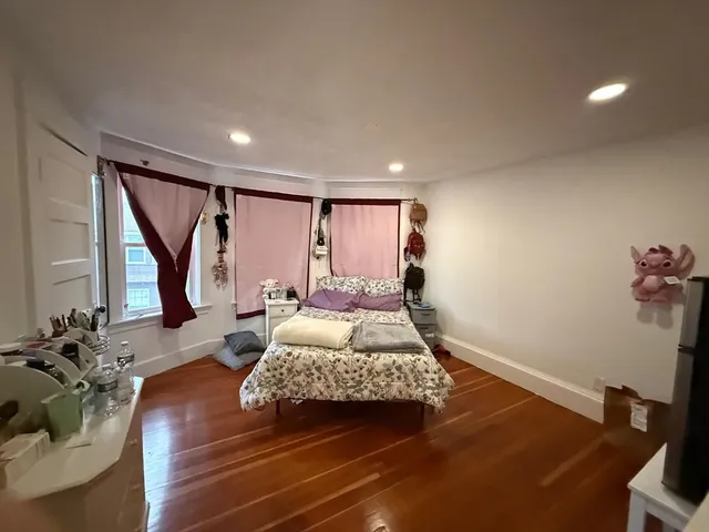 a bedroom with furniture and a wooden floor