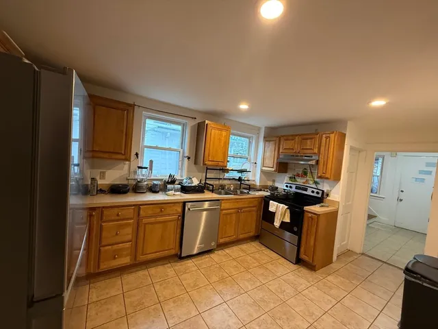 a kitchen with stainless steel appliances granite countertop a stove a sink dishwasher and a refrigerator