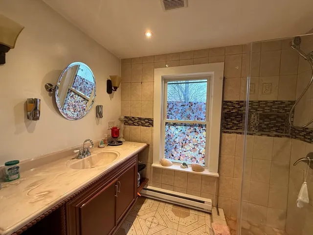 a bathroom with a sink a mirror and a shower
