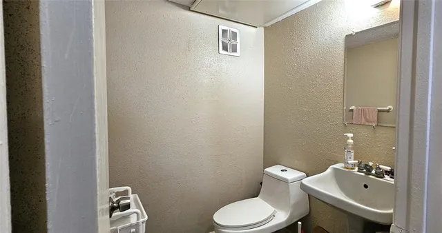 a white toilet sitting next to a bathroom sink