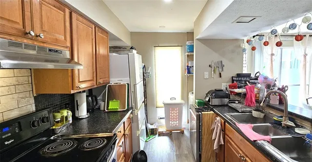 a kitchen with stainless steel appliances kitchen island granite countertop a stove and a sink