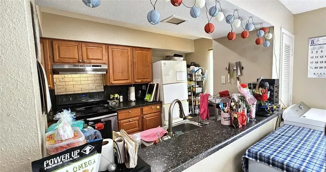 a kitchen area with stainless steel appliances kitchen island granite countertop a stove and a refrigerator