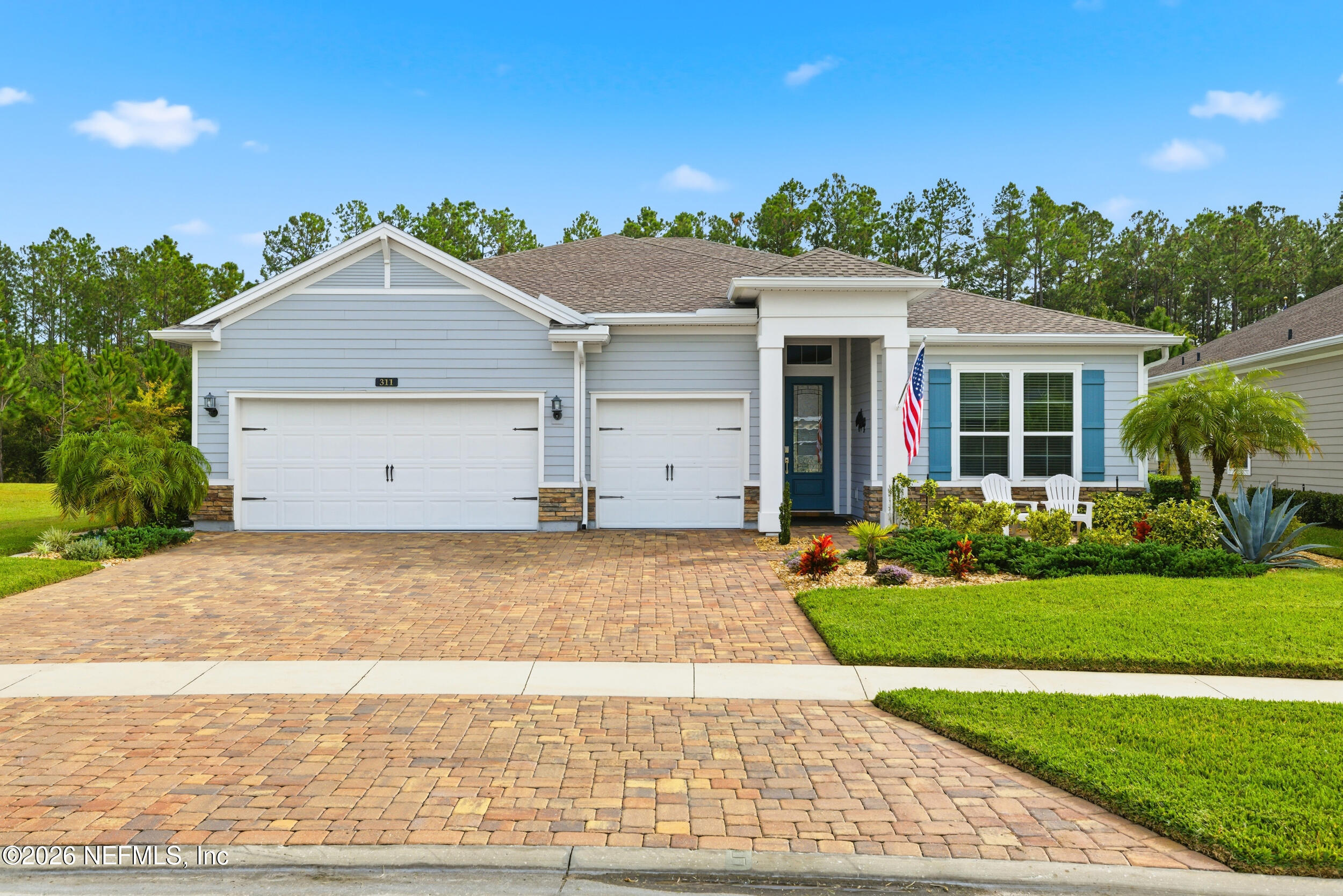 a view of a house with a yard and potted plants