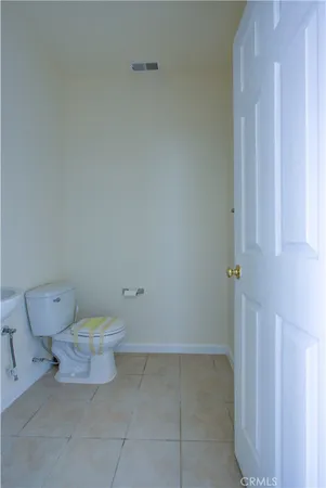 a white toilet sitting next to a white cabinet