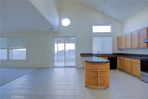 a kitchen with granite countertop a sink dishwasher stove and cabinets