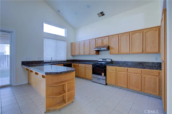 a kitchen with stainless steel appliances granite countertop a stove a sink and a refrigerator