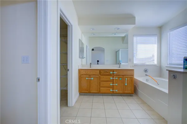 a bathroom with a granite countertop tub sink and mirror