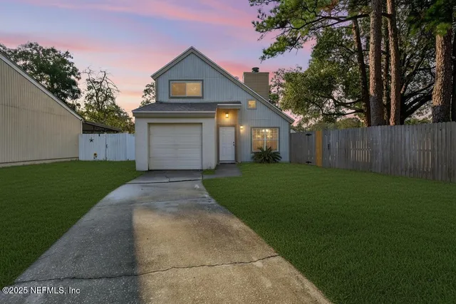 a front view of a house with a yard and trees