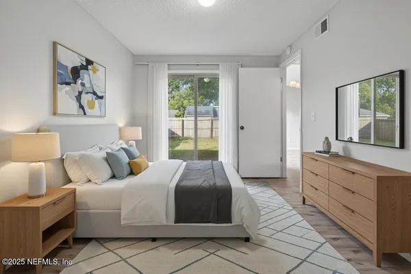a spacious bedroom with a bed and a large window
