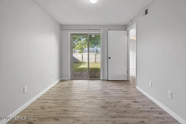 a view of a room with wooden floor and a window