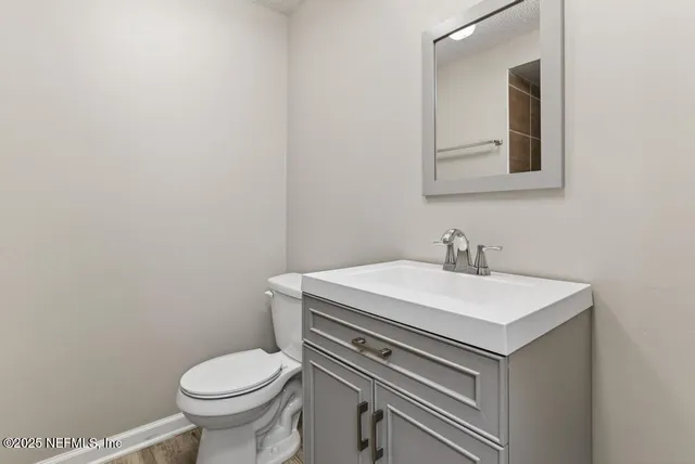 a bathroom with a sink toilet and mirror