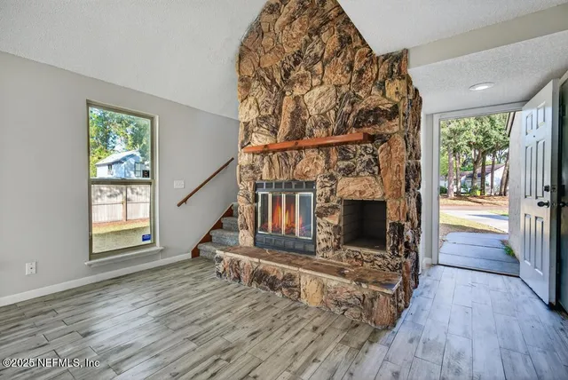 wooden floor fireplace and windows in an empty room