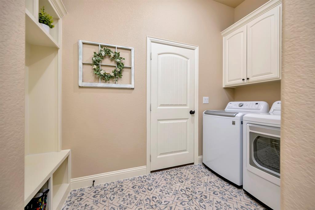 3224 North Cardinal Road Azle, TX 76020 - Photo 29 of 40 Utility room featuring patterned tile flooring, built-in shelving, white cabinetry, and a paneled door