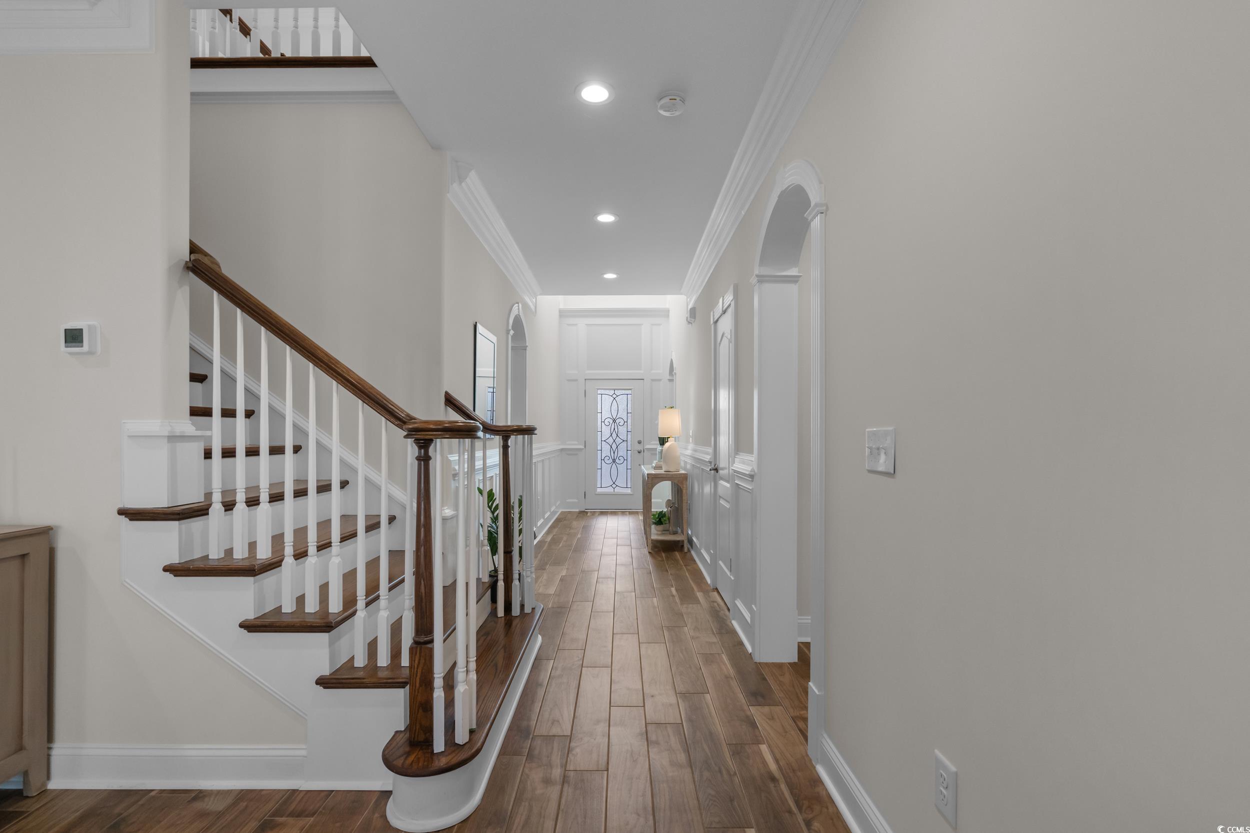 3021 Moss Bridge Lane Myrtle Beach, SC 29579 - Photo 7 of 40 Hall featuring crown molding, stairs, dark wood finished floors, recessed lighting, and arched walkways