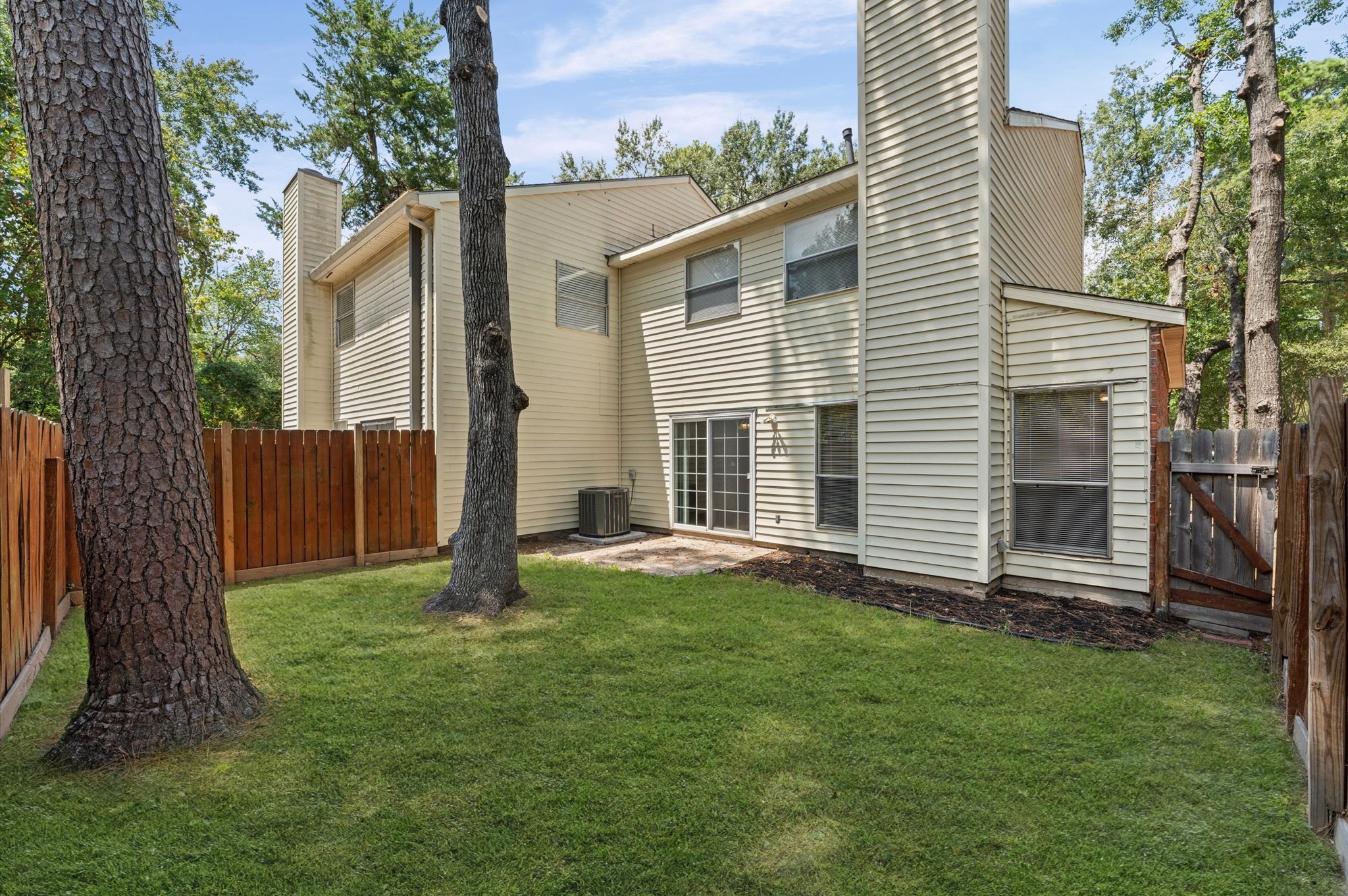 4 Blue Fox Court Spring, TX 77380 - Photo 12 of 13 The fully fenced backyard has mature trees, green space, and a small patio outside the living area