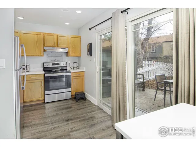 a kitchen with stainless steel appliances a stove a refrigerator a sink a oven with wooden floor