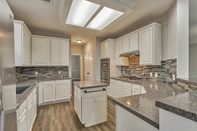 a kitchen with stainless steel appliances granite countertop a sink stove and refrigerator
