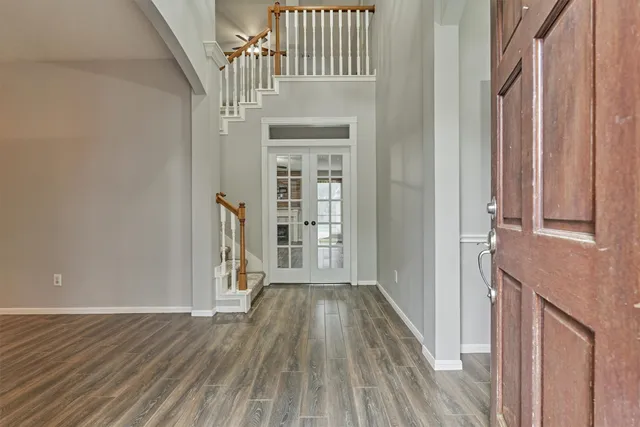 a view of a hallway with wooden floor and staircase