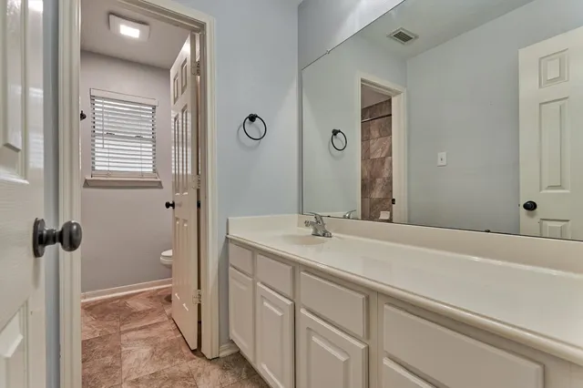 a bathroom with a sink and a mirror with bathtub