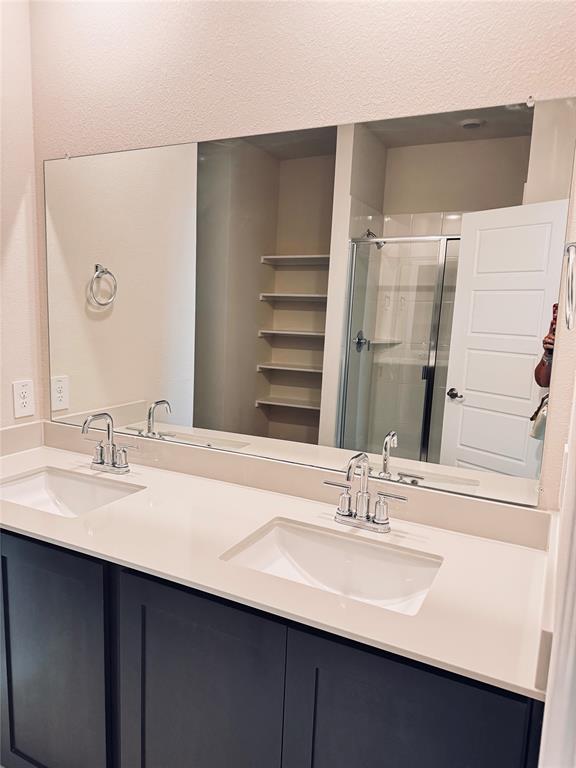 2625 Lewisville Road Celina, TX 75009 - Photo 7 of 7 Dual sink vanity featuring dark cabinetry and light countertops