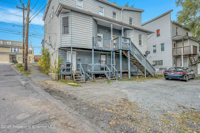 a view of road with large trees and a big yard