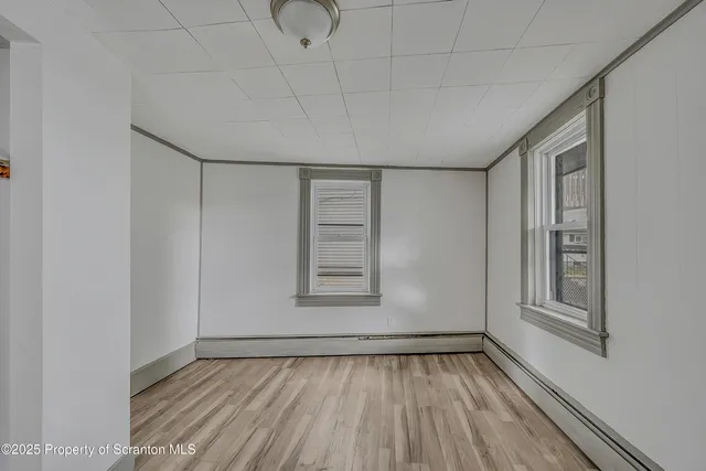 a view of empty room with wooden floor