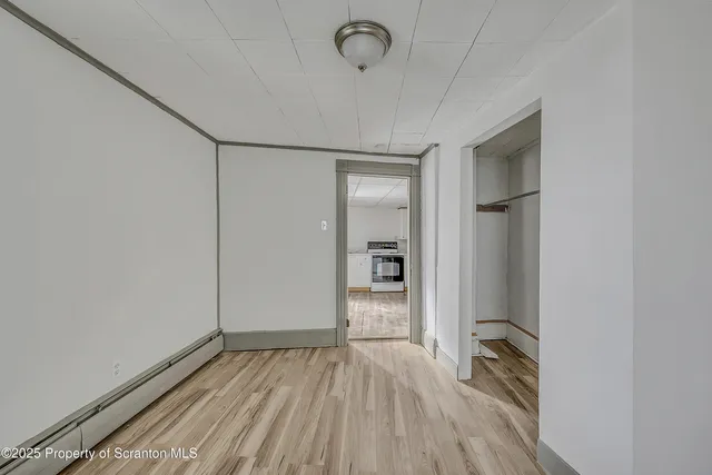 a view of a hallway with wooden floor and a window
