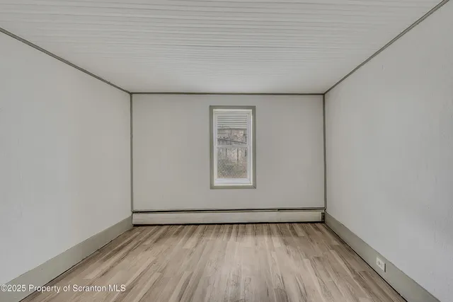 a view of a room with wooden floor and a window