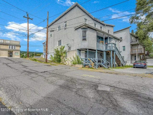 a view of a house with a swimming pool and a large tree