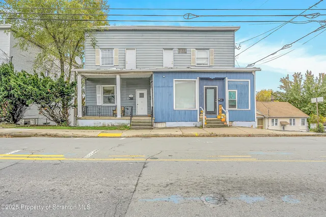a view of a house with a backyard and a garage
