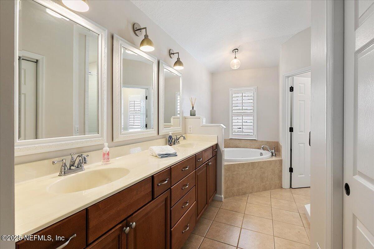 321 Fifth Street Atlantic Beach, FL 32233 - Photo 22 of 33 a bathroom with a granite countertop double vanity sink a mirror and a bathtub