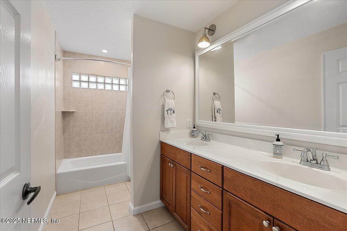 321 Fifth Street Atlantic Beach, FL 32233 - Photo 25 of 33 a bathroom with a tub sink double vanity and a mirror