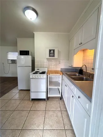 a kitchen with a sink a stove top oven and cabinets