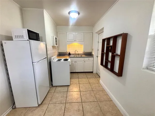a kitchen with a refrigerator sink stove and cabinets