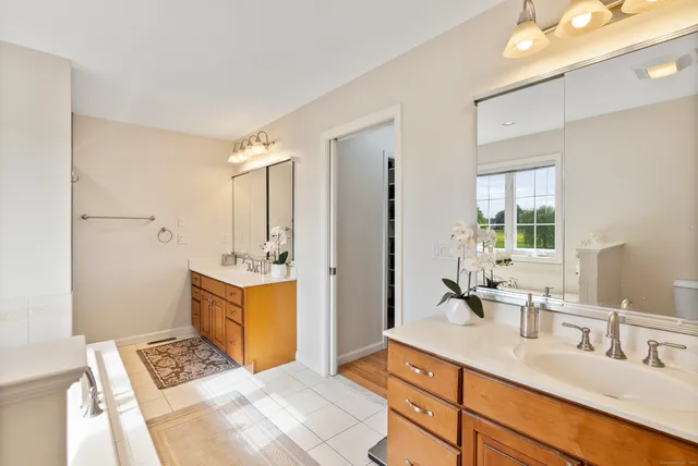 a spacious bathroom with a double vanity sink a mirror and a shower