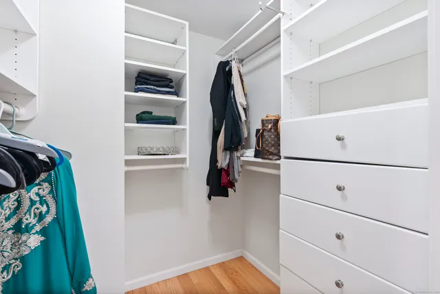a view of walk in closet with clothes and shoes