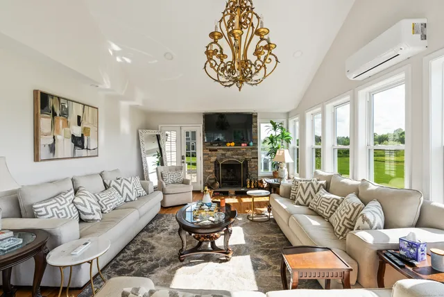 a living room with furniture large window and a fireplace