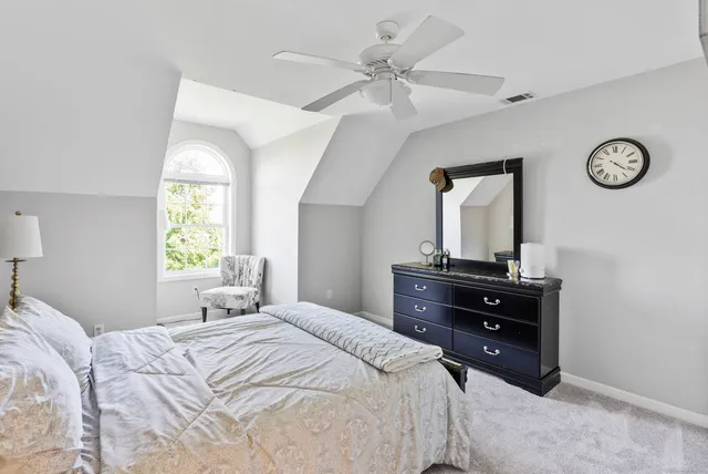 a bedroom with a bed and a table with a large mirror