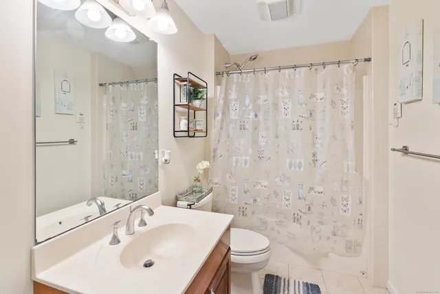 a bathroom with a sink a toilet and shower curtain