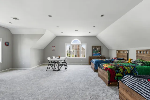 a bedroom with furniture and a large window