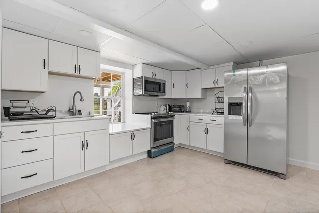 a kitchen with cabinets stainless steel appliances and sink