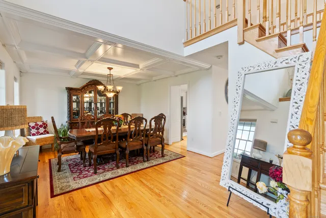 a view of a dining room with furniture one side kitchen view and wooden floor