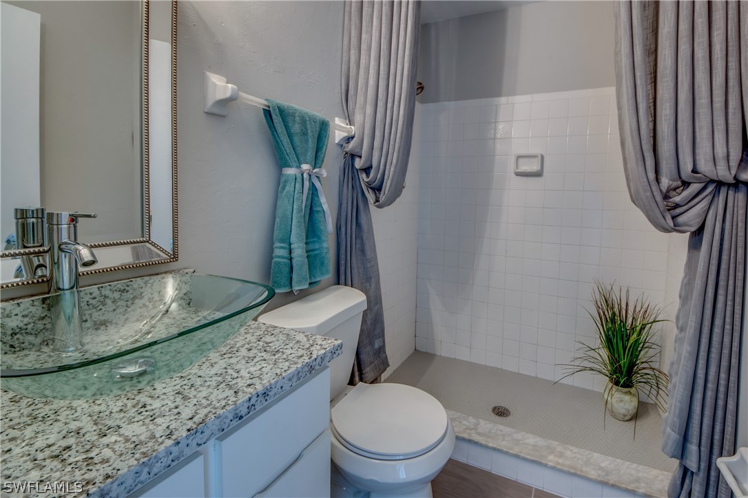 17520 Oriole Road Fort Myers, FL 33967 - Photo 15 of 25 a bathroom with a granite countertop sink a toilet and a mirror